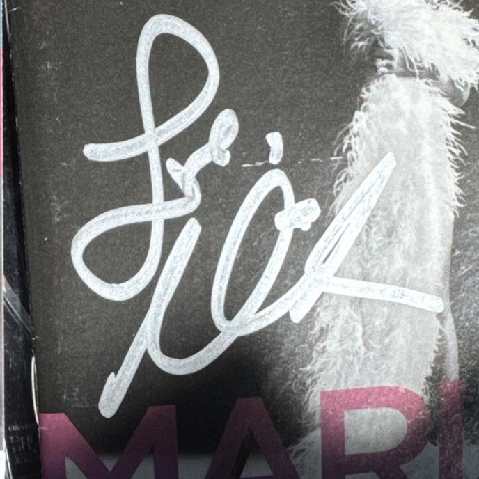 A signed album cover showing Love and an abbreviated Mariah Carey name written large in marker across the printed sleeve.