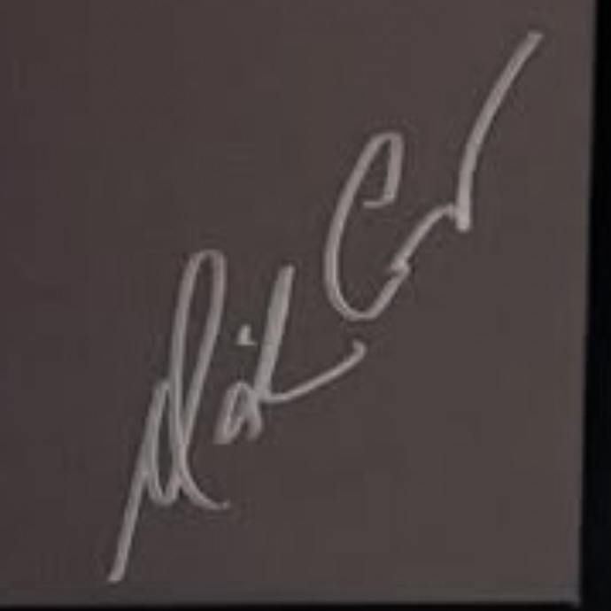 Close-up of a modern abbreviated Mariah Carey signature in marker showing pointed peaks, a triangular crossbar element and a long tapering trailing exit stroke.
