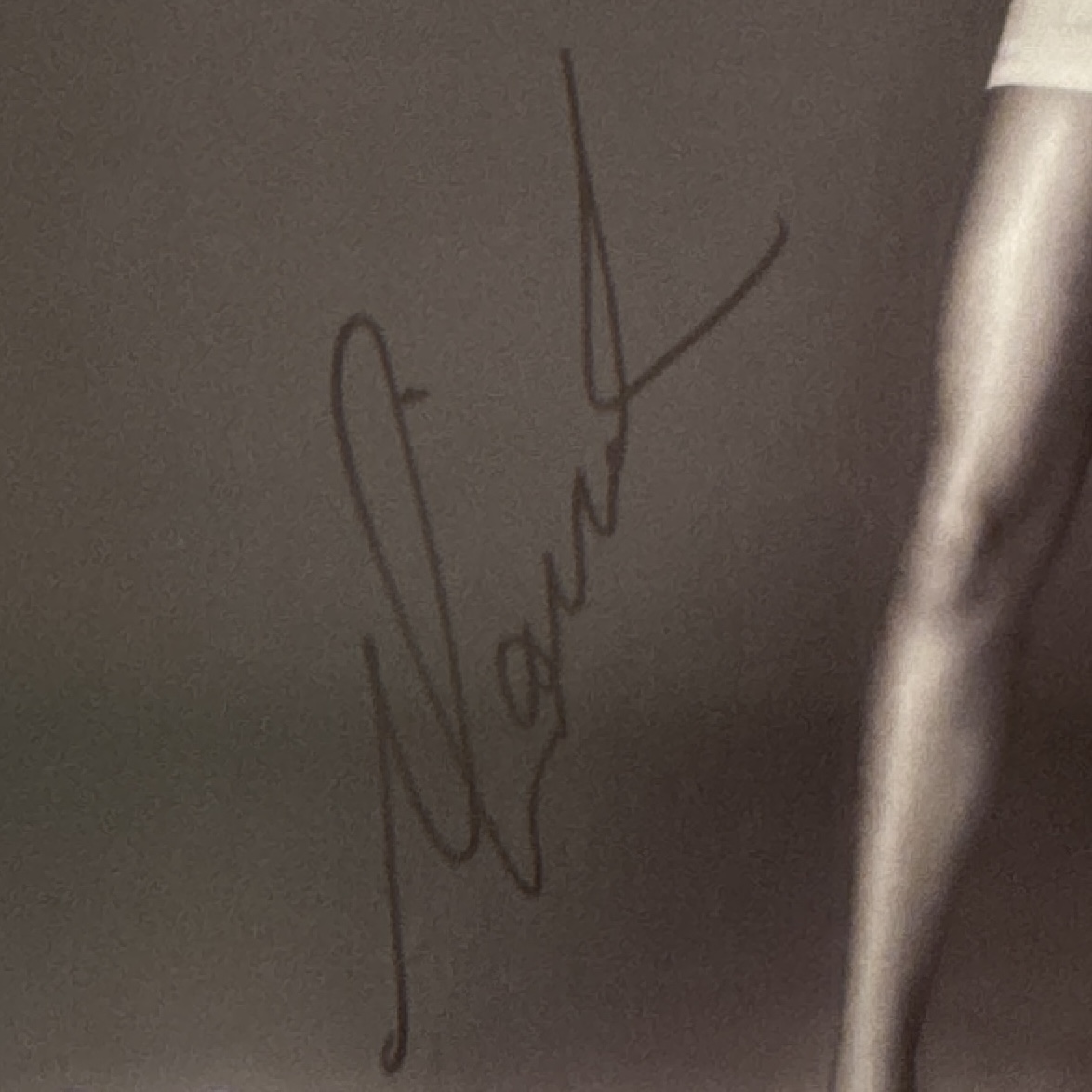 Two Mariah Carey signatures in dark marker on printed photographs, shown together for stroke comparison.