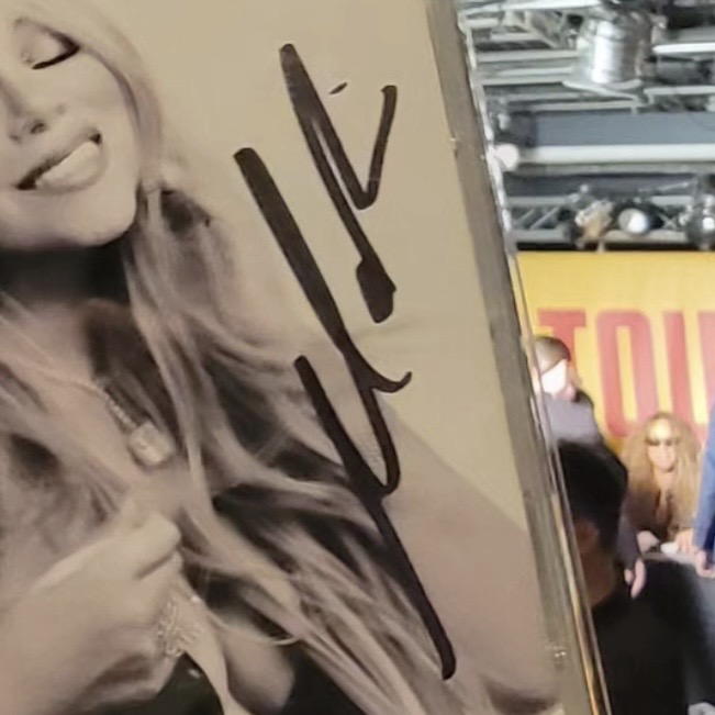 A sepia-toned photograph signed in marker, shown as an example of a quickly written signature added in a live setting.