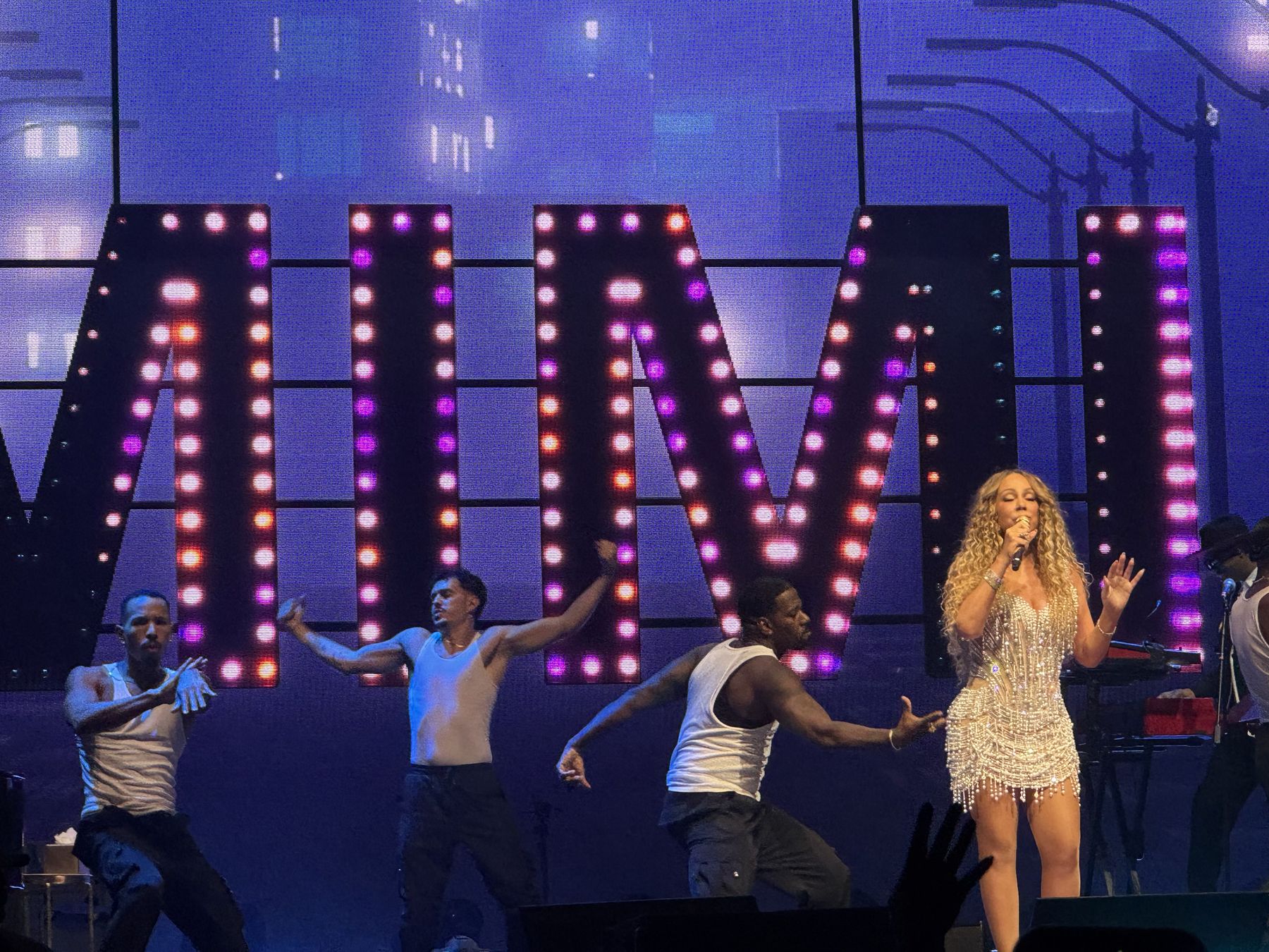 Mariah Carey performing with dancers in front of illuminated MIMI letters in Pasay in 2025